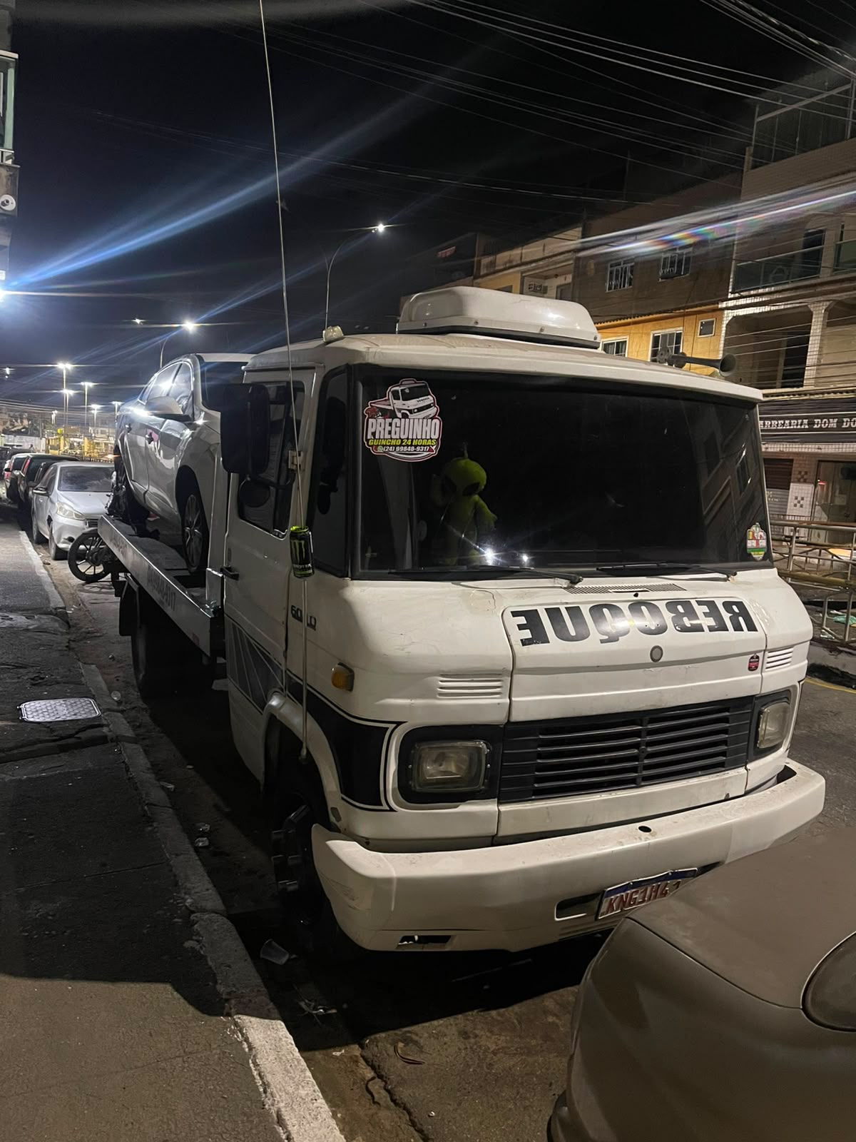Guincho Mercedes-Benz transportando carro prata à noite